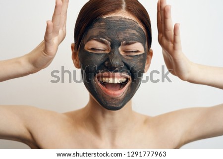joyful woman in clay mask on face portrait care procedure