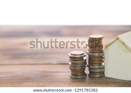 Stack of coins on old white wooden floor. ideas about saving money for house - business success concept.