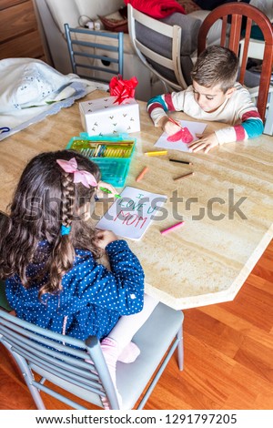 Two children drawing greeting cards for mother's day