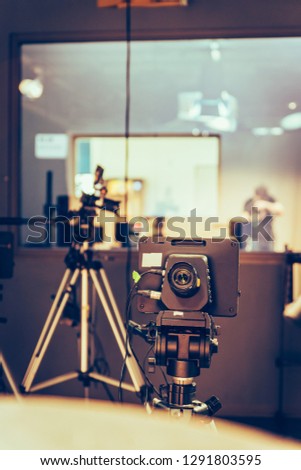 Film camera on a tripod in a television broadcasting studio, spotlights and equipment