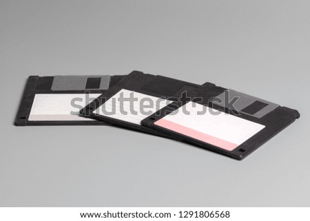 Three old computer diskette over grey  background