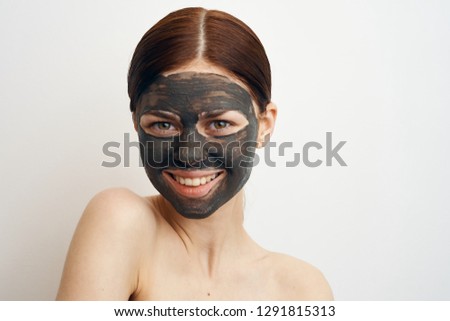 woman smiling in a cosmetic clay mask portrait
