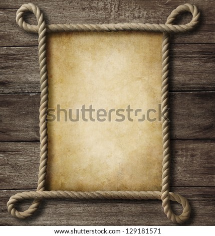 aged paper with rope frame on old wood background