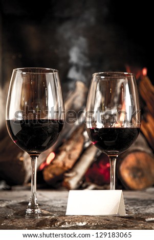 Glass of wine with fireplace on the background.