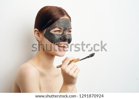 joyful woman with a cosmetic mask in hand makeup brush beauty spa care