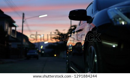 luxury vehicle black car travel road trips at night city with blur beautiful twilight dramatic sky, image selective focus on side mirror