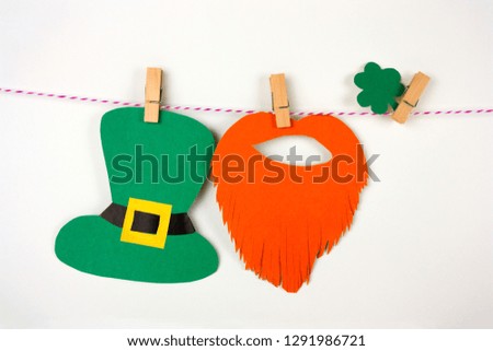 St Patrick's paper decorations on clothespins on a white backgroun