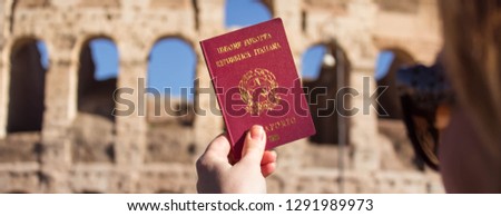the passport in the hand of a girl on the background of attractions in Rome