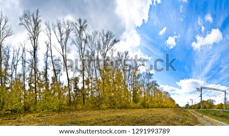 Beautiful background and view, landscape and panorama of the railway line and the nature of autumn against the blue sky with clouds.