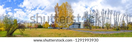 Beautiful and original panorama. Beautiful background and view, landscape and panorama of the city park and square with an alley and building against the blue sky with clouds in the fall.