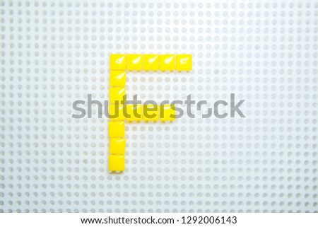 letter F created with children toys similar to pixels