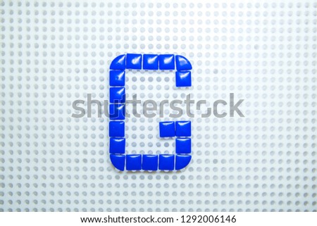 letter G created with children toys similar to pixels