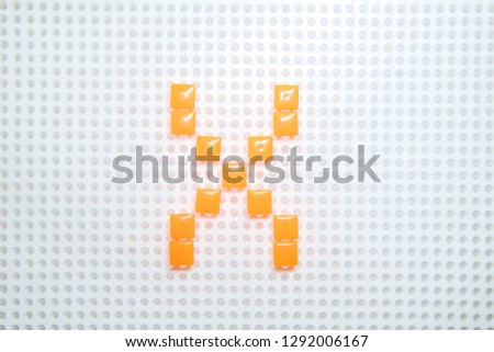 letter X created with children toys similar to pixels
