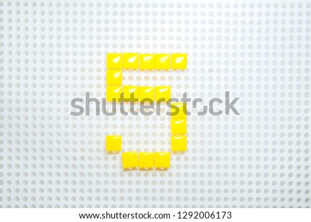 number 5 created with children toys similar to pixels