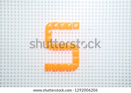 letter S created with children toys similar to pixels