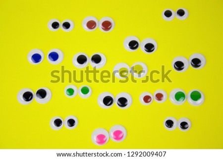 googly eyes on yellow pastel background,top view flat lay