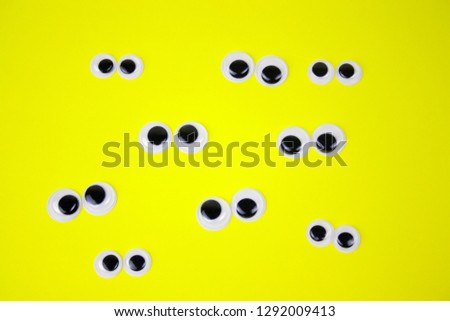 googly eyes on yellow pastel background,top view flat lay