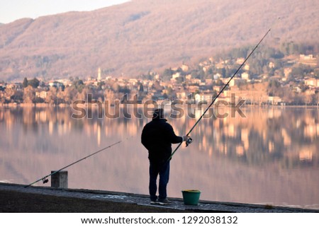 A fisherman on the pier with the reflection of the water