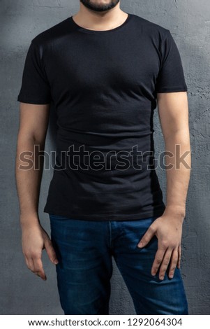 Young healthy man with black T-shirt on concrete background. Picture without model face.