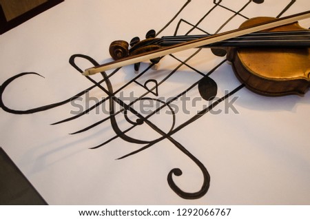 Close up of Violin handle with bow  positioned in a diagonal over a diagonal musical stave drawing with a G-clef with musical notes on a white background