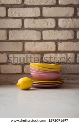 bright yellow lemon near a set of bright ware in interior