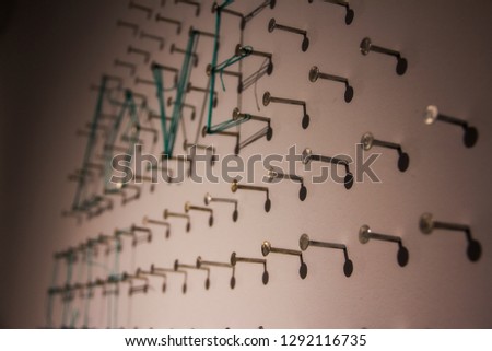 string attached to nails on the wall