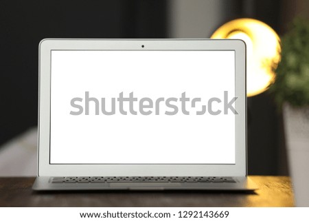 Laptop with blank screen on table indoors. Space for text