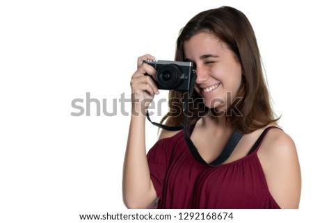 Teenage girl taking a photograph with a modern digital camera and similing - Isolated on white