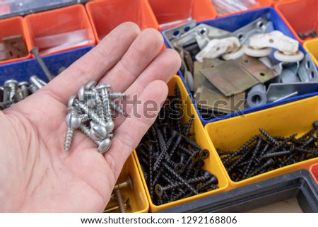 Bolts and pegs for home repair. Accessories for mechanics on a workshop table. Light background.