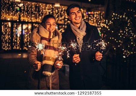 Couple having fun with sparklers outdoors