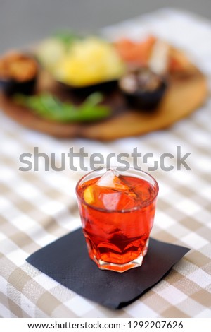 Italian aperitives/aperitif: glass of cocktail (sparkling wine with Aperol) and appetizer platter on the table. Traditional italian cuisine.