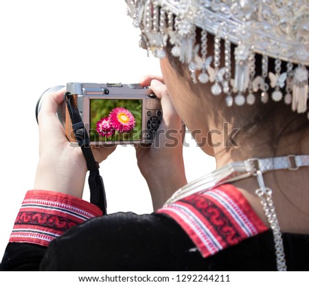 Pretty girl using a digital camera to taking pictures of flowers. White background