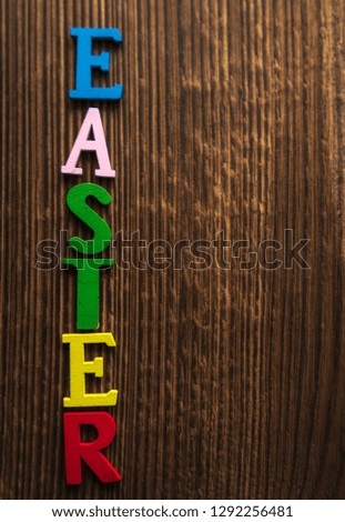 the word "Easter" is laid out on a wooden background in colored letters