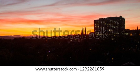 Sunset landscape image with the dark city. An image showing the power of nature and how beautiful it can be. Bright yellow, blue and orange colours blend in the sky creating an amazing view.