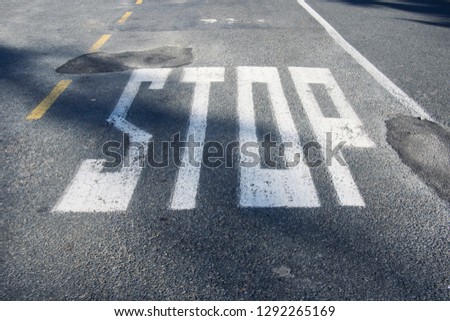 Stop sign painted on asphalt road