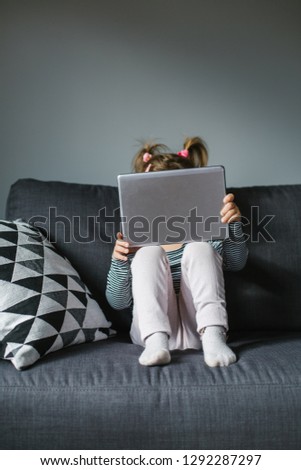 Little girl with a digital tablet at home