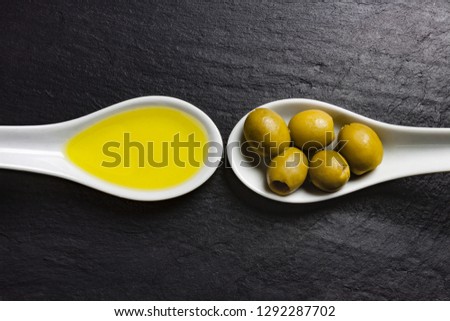 VIEW OF WHITE SPOONS WITH OLIVES AND OLIVE OIL Royalty-Free Stock Photo #1292287702