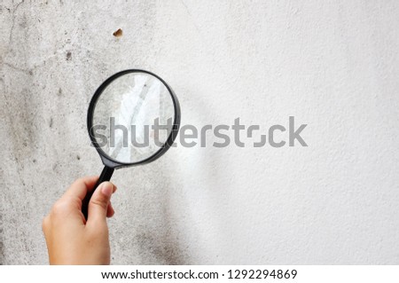 top view hand holding a magnifying glass on a white background