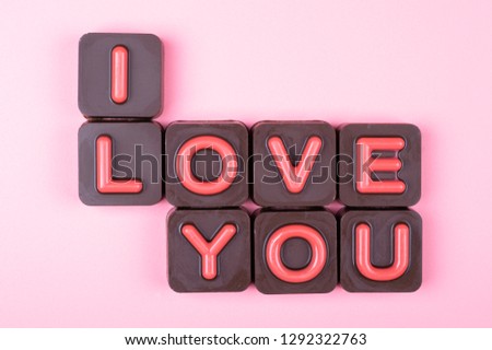 I love you engraved in chocolate on colored background