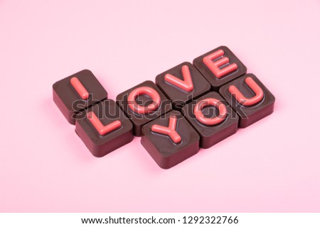I love you engraved in chocolate on colored background