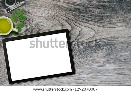 Office desk with blank screen mockup tablet ,tea cup and camera, copy space for product display.
