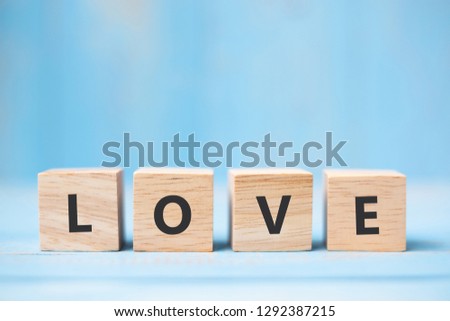 LOVE wooden cubes on blue table background with copy space for text. Wedding, Romantic and Happy Valentine’s day holiday concept