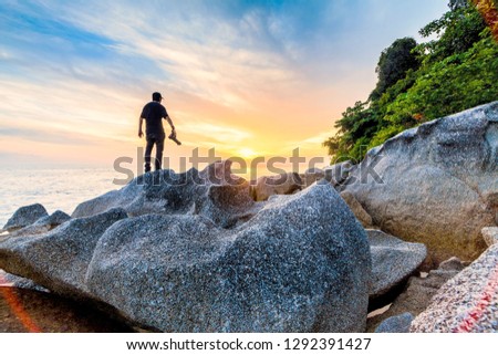 Silhouette view of male model photographer by sunrise or sunset background