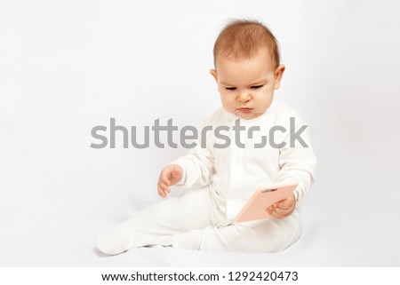 Baby holding a mobile phone isolated on white background