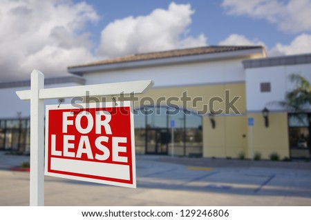 Vacant Retail Building with For Lease Real Estate Sign in Front.