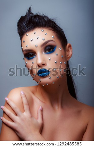 Makeup in the style of beauty. Bright lips and eyes. Portrait of a beautiful young girl. Journal detailed skin retouching. Expressive eyebrows. Huge eyelashes. Neon shadows.