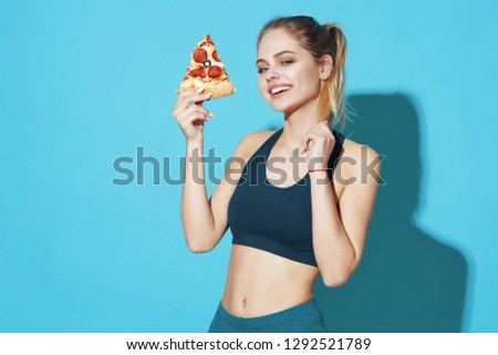 a woman in a dark t-shirt plays sports and holds a pizza in her hand