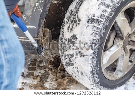 Winter, snow, car. A man cleans the car from the snow and ice with a special brush