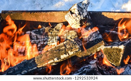 Burning firewood in the fireplace  close up , wintertime,charcoal background