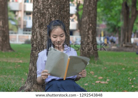 Beautiful young asian school girl who reads a book.